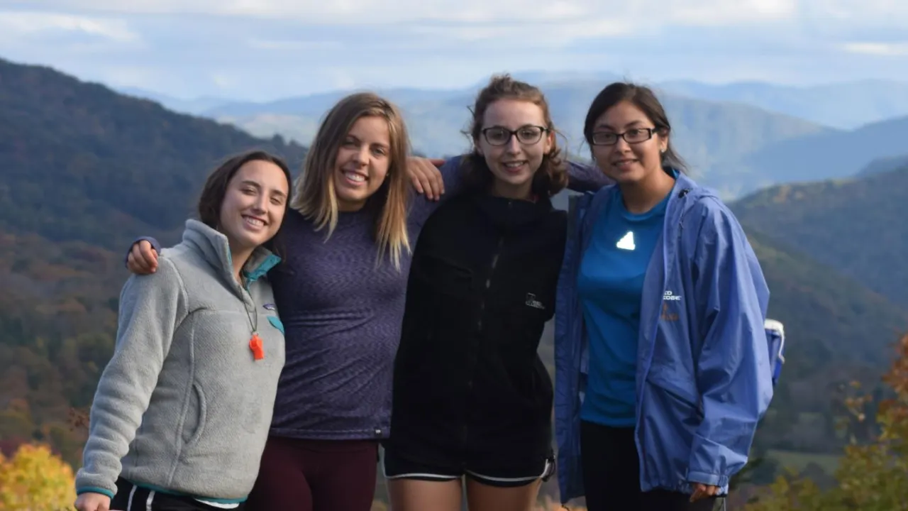 Four students on top of a mountain for a Venture Outdoor Leadership trip