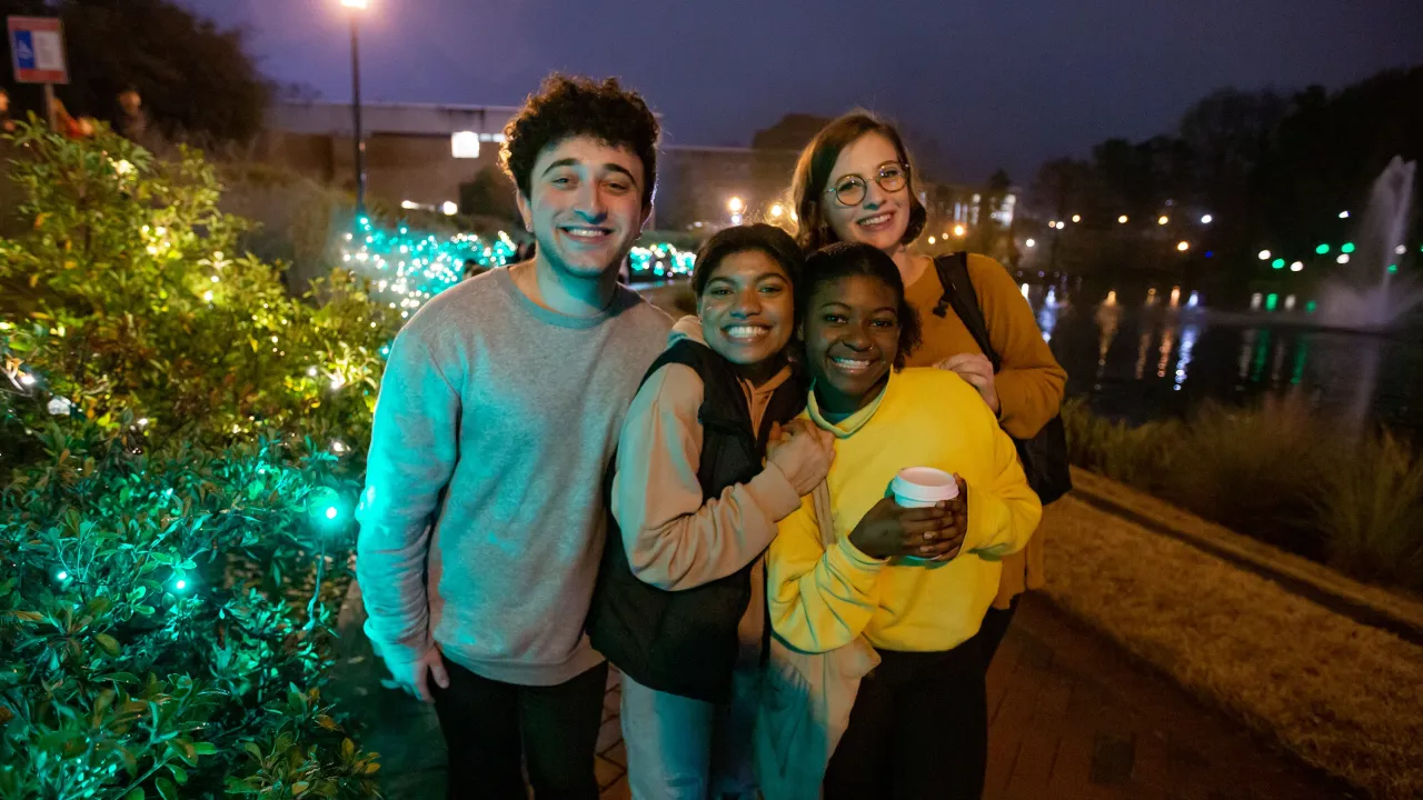 Students smiling among the lights at Light Up The Lake