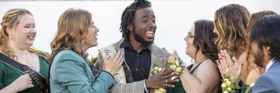 Ra'Quan Leary smiling and talking to the other Niner 9 members after winning the Golden Niner.