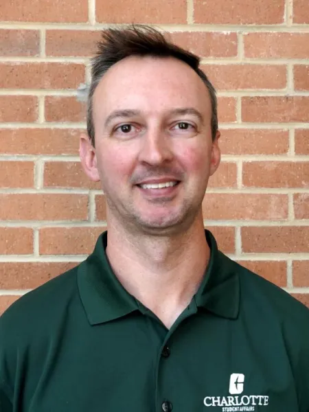 Adam Burden smiling in a UNC Charlotte polo