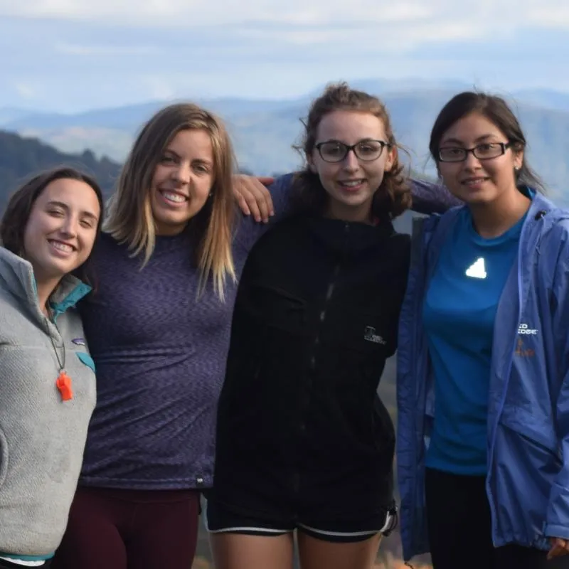 Four students on top of a mountain for a Venture Outdoor Leadership trip